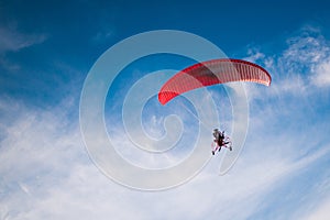 Red paraglider on a cloudy background