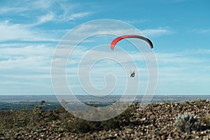 Red paragliding take offs on beautiful blue sky with clouds photo