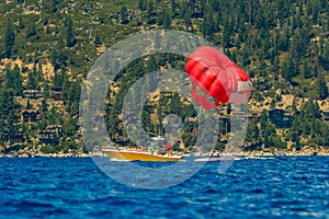 Red parasail wing pulled by a boat on lake Tahoe in California, USA