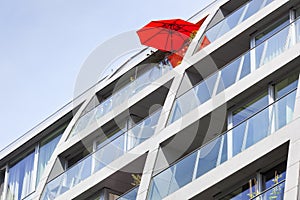 Red parasol on an apartment building balcony