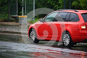 Red passenger car in the summer rain photo