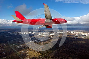 Red passenger plane in flight. Side view.