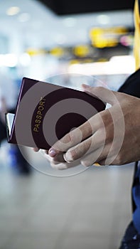 red passport open at the airport by white hands photo