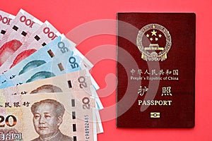 Red passport of People Republic of China and chinese yuan money bills. PRC chinese passport