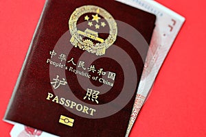 Red passport of People Republic of China and chinese yuan money bills. PRC chinese passport