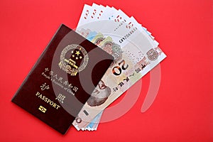 Red passport of People Republic of China and chinese yuan money bills. PRC chinese passport