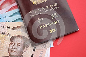 Red passport of People Republic of China and chinese yuan money bills. PRC chinese passport