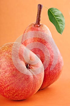 Red pear fruits with green pear leaf on red background