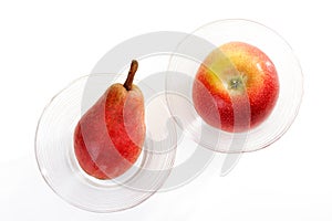 Red pear and red apple in glass bowl