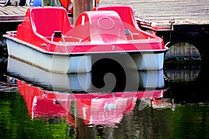 Red pedalo reflecting in water