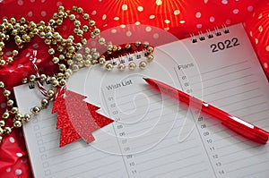 Red Pen Point to Wish List Notes on Red Background in Christmas Concept