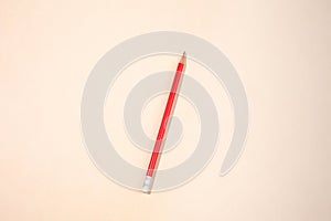 Red pencil on a beige paper background with copy space for your text