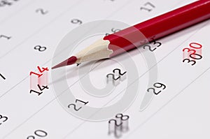 Red pencil over calendar