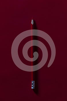 Red pencil on a red background with hard shadow. Perfect for the start of class. Red pencil for teacher qualifications.