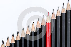 Red pencil standing out from crowd of plenty identical black fellows