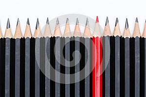 Red pencil standing out from crowd of plenty identical black fellows