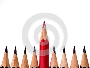 Red pencil standing out from crowd of plenty identical black fellows on white background. business success concept