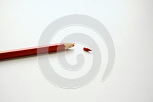 Red pencil on a white background. Broken kalandash tip, concellaria, school supplies