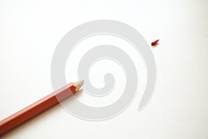 Red pencil on a white background. Broken kalandash tip, concellaria, school supplies
