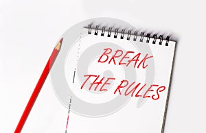 Red pencil and white notepad with the text BREAK THE RULES