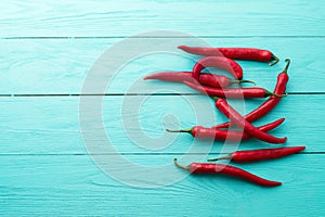 Red pepers on blue wooden kitchen background. Copy space and mock up