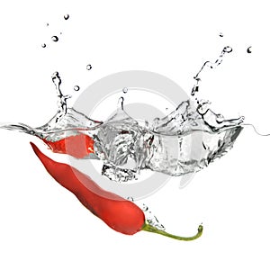 Red pepper dropped into water with splash