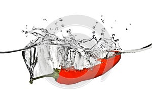 Red pepper dropped into water with splash