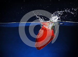 Red pepper falling into water