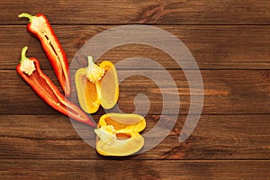 Red pepper Kapi with yellow sweet pepper on a wooden background, space for text.