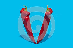 Red pepper split on half standing on blue background