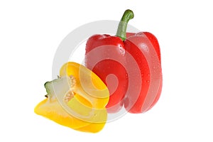 A red pepper with stem and a half of yellow pepper covered by wa