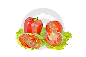 Red pepper and tomato with slices on lettuce leaves.