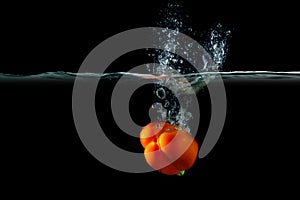 Red pepper in water with splashes