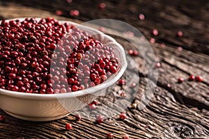 Red peppercorn in bowl on oak table