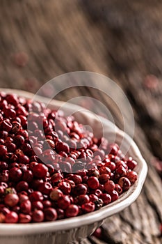 Red peppercorn in bowl on oak table