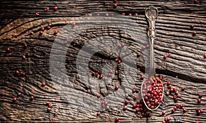 Red peppercorn on spoon on oak table