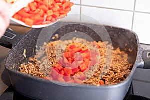 Red peppers being added to minced meat