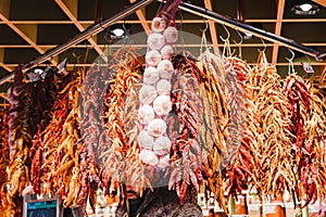 Red peppers, orange peppers, yellow peppers and garlic, hanged in the market