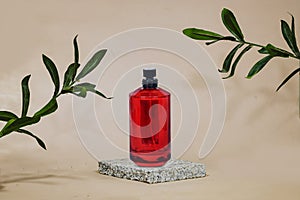red perfume bottle on marble podium or showcase with ruscus plant