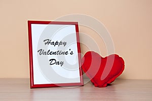 Red photo frame and heart on wooden table