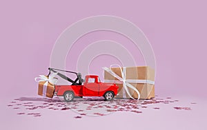 Red pickup car carrying a gift for the holiday with purple glitter on violet background. New year, holiday, birthday, christmas,