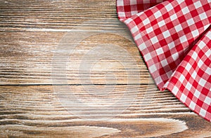 Red picnic cloth on wooden background.Napkin tablecloth on old w