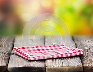 Red picnic cloth on wooden table mature bokeh background. photo