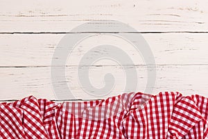 Red picnic tablecloth on rustic white wooden table background, top view, copy space