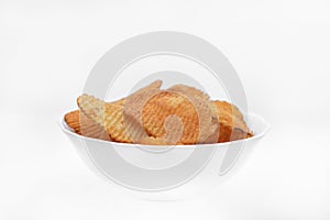 Red pieces of fried potatoes in a plate. Peppery chips on a white background