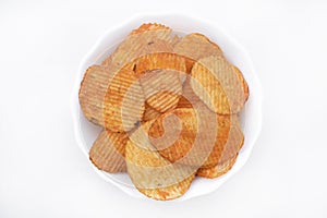 Red pieces of fried potatoes in a plate. Peppery chips on a white background