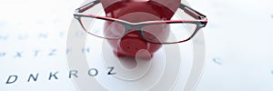 Red pig in glasses stands on ophthalmological table closeup photo