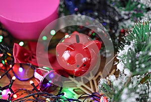 Red piggy bank standing near Christmas gifts and tinsel closeup