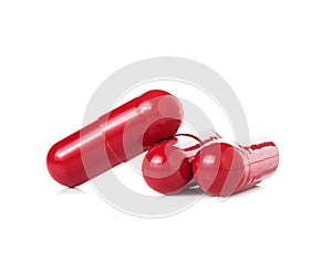 Red pill capsules on white background