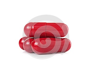 Red pill capsules on white background